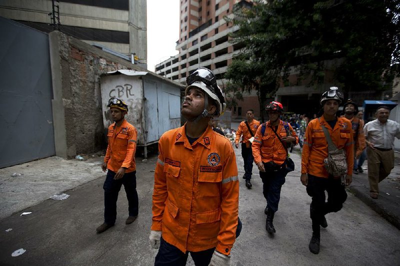 Civil protection workers in Caracas, Venezuela, prepare to climb the abandoned Tower of David skyscraper and secure its top floors after Wednesday’s earthquake.