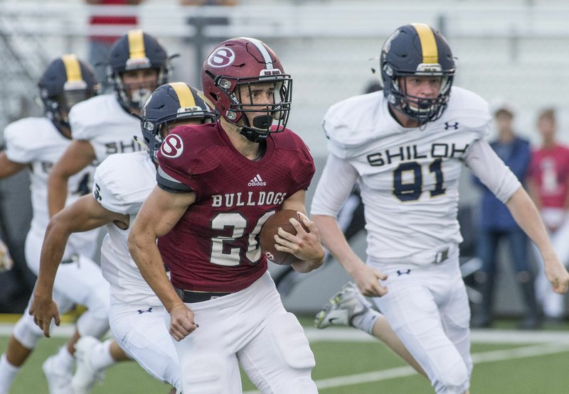 NWA Democrat-Gazette/BEN GOFF @NWABENGOFF Garrett Vaughan (20), Springdale High running back, runs the ball Tuesday, Aug. 14, 2018, during a scrimmage against Shiloh Christian at Jarrell Williams Bulldog Stadium in Springdale. Vaughan has added 10 pounds over the offseason and will lead the Bulldogs into the season-opener at home tonight against Joe T. Robinson.