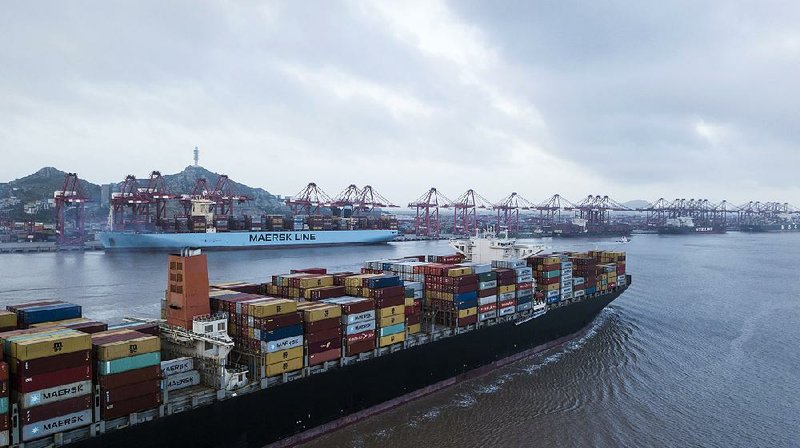 A container ship sails out of the port in Shanghai, China, in July. As the trade dispute with the United States deepens, Chinese leaders have promised to help its struggling exporters. 