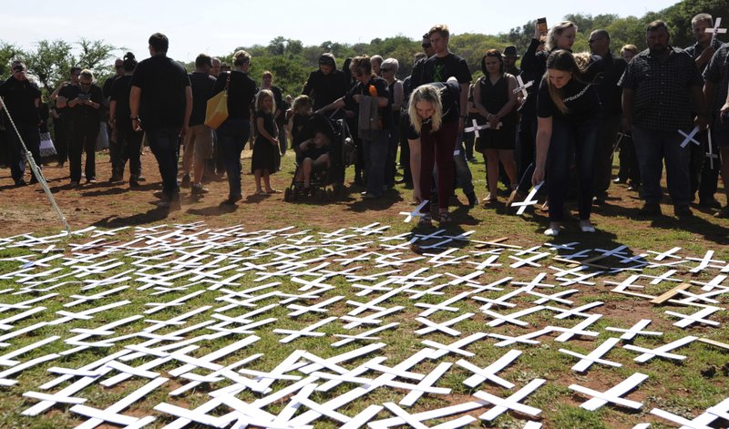 In this photo taken Oct. 30, 2017 people place white crosses, representing farmers killed in the country, at a ceremony at the Vorrtrekker Monument in Pretoria, South Africa. U.S. President Donald Trump has tweeted that he has asked the Secretary of State Mike Pompeo to "closely study the South African land and farm seizures and expropriations and the large scale killing of farmers." Trump added, "South African Government is now seizing land from white farmers." (AP Photo)