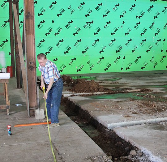 The Sentinel-Record/Richard Rasmussen GOOD SAMARITAN: President of the board for Samaritan Ministries, Charles Laggan, takes a measurement at the construction site for the ministry’s new apartment complex.