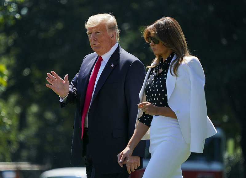 President Donald Trump and first lady Melania Trump walk across the South Lawn of the White House on Friday as they leave for a campaign rally in Columbus, Ohio.