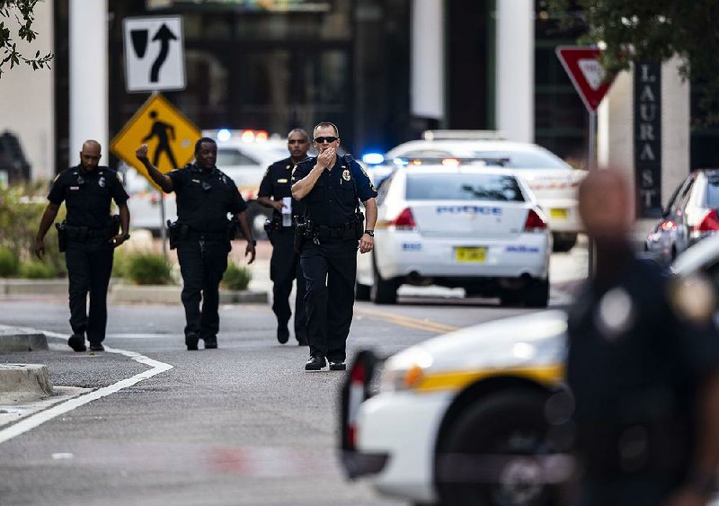 Police gather after an active shooter was reported at the Jacksonville Landing on Sunday in Jack- sonville, Fla.