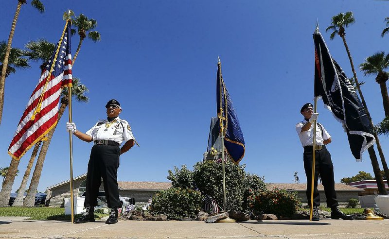 Members of the POW-MIA-KIA Honor Guard stand Sunday in front of a local mortuary where the body of the late Arizona Sen. John McCain is kept in Phoenix.