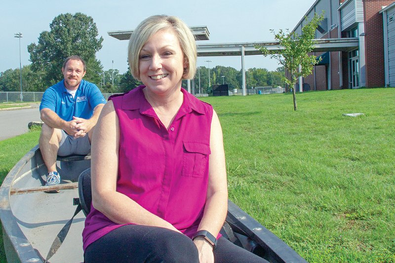 Tammy Denham, executive director for the Boys & Girls Club of Malvern and Hot Spring County, front, and Dylan Briner sit in a canoe on the front lawn of the club. The club is seeking donations of outdoor equipment to help expose students to activities such as fishing, camping and hiking. 