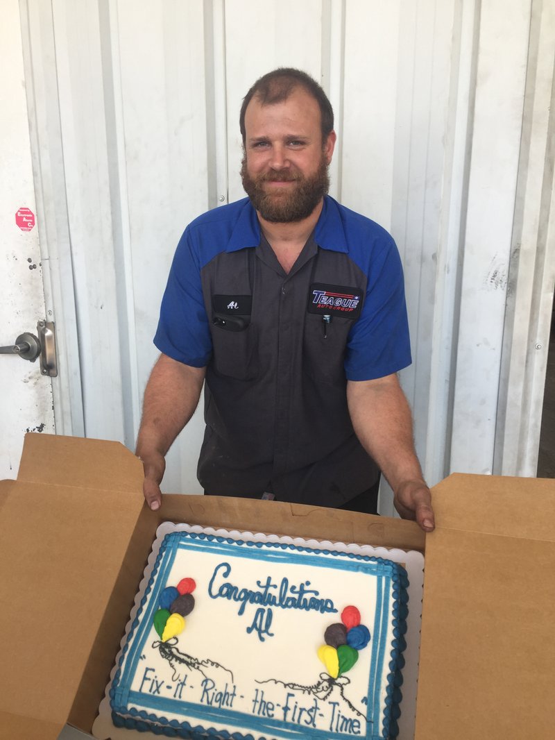 Al Gray, a technician with Teague Ford Lincoln in El Dorado, shows off a cake meant to celebrate his achievement in ranking ninth in the national Prestigious Performance Challenge. Gray overcame severe nerve damage from a car accident to work his way up to technician at the dealership.
