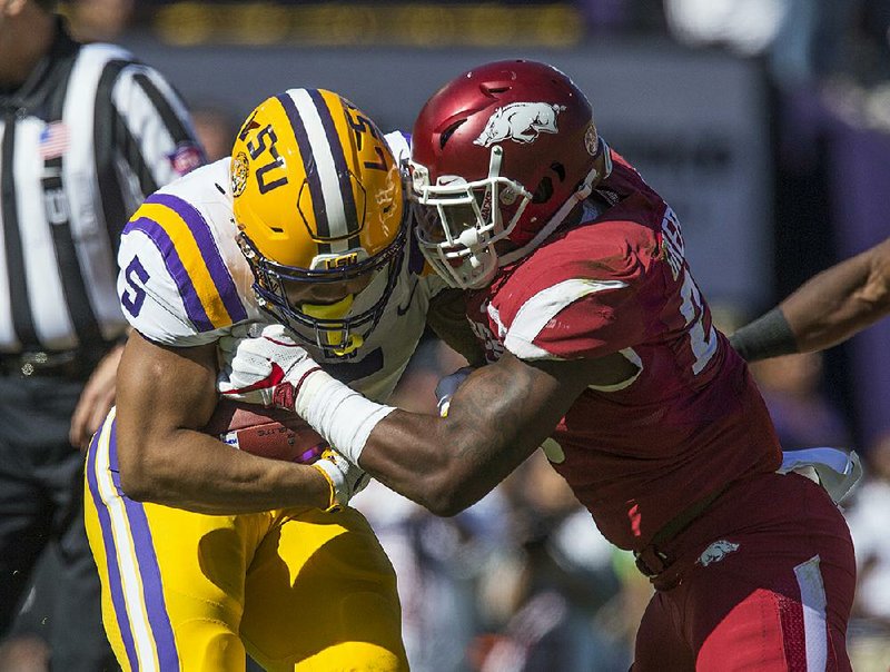 Arkansas linebacker Dre Greenlaw tackles LSU running back Derrius Guice in a Nov. 11 game at Tiger Stadium in Baton Rouge. After nearly seven years of calling Greenlaw their son, Brian and Nanci Early officially adopted him in July, shortly after he turned 21.