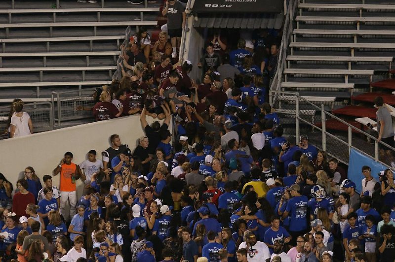 Fans rush to leave War Memorial Stadium on Saturday night after a fight set off a panic in the stadium during the Salt Bowl.