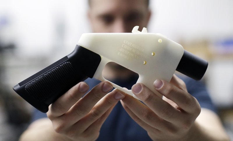 FILE - In this Aug. 1, 2018, file photo, Cody Wilson, with Defense Distributed, holds a 3D-printed gun called the Liberator at his shop in Austin, Texas. A federal judge in Seattle has granted an injunction that prohibits the Trump administration from allowing a Texas company to post 3D gun-making plans online. (AP Photo/Eric Gay, file)