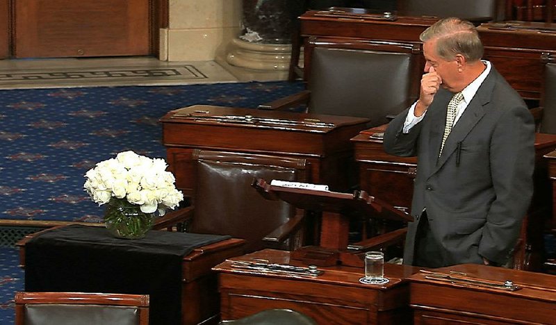 Sen. Lindsey Graham, R-S.C., pauses Tuesday during a tribute on the Senate floor to his close friend, the late Sen. John McCain, whose desk is draped in black with a bouquet sitting on it. “It is going to be a lonely journey for me for a while,” Graham said while fighting back tears, reading from handwritten notes. “The void to be filled by John’s passing is more than I can fill. Don’t look to me to replace this man,” Graham said.
