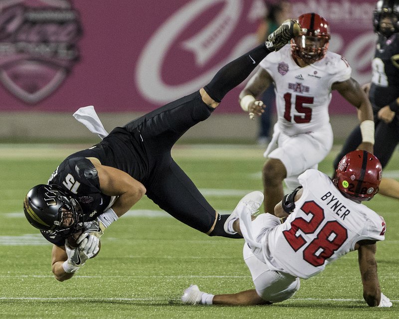 FILE — Arkansas State Red Wolves defensive back Brandon Byner (28) tackles UCF Knights tight end Jordan Franks (15) during a football game between the UCF Knights and the Arkansas State Red Wolves at The Cure Bowl located at Camping World Stadium in Orlando, Florida on December 17, 2016. Special to the Arkansas Democrat Gazette/ROB HERBERT 
