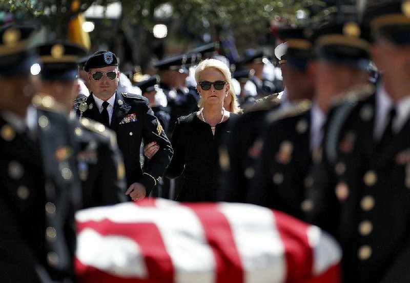 U.S. Sen. John McCain’s son Jimmy and widow, Cindy, follow McCain’s casket as it is carried into the Arizona Capitol for Wednesday’s memorial service.  