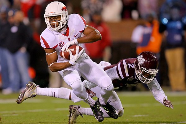 Arkansas receiver Jared Cornelius breaks a tackle by Mississippi State State's Will Redmond during a game Saturday, Nov. 1, 2014, in Starkville, Miss. The Razorbacks will wear all-white uniforms Saturday for the first time at home and for the first time since the 2014 season. 