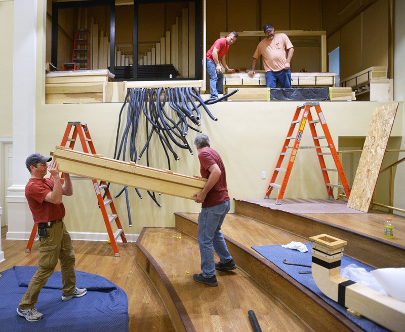 NWA Democrat-Gazette/ANDY SHUPE Chris Goodnight (from left), and Tracey Mitchell, lift a wind chest Wednesday as fellow craftsmen Joe Granger and Mike Meyer, prepare to install it while constructing a new organ in the sanctuary at Central United Methodist Church in Fayetteville. The organ was a gift from an anonymous church member and will require more than a year, from concept to final installation, to be complete. Workers are constructing the instrument at their facility in Champaign, Ill., and bringing it down to install it over an expected 30 work days during the coming months as a part of a larger renovation of the sanctuary and its music apparatus.
