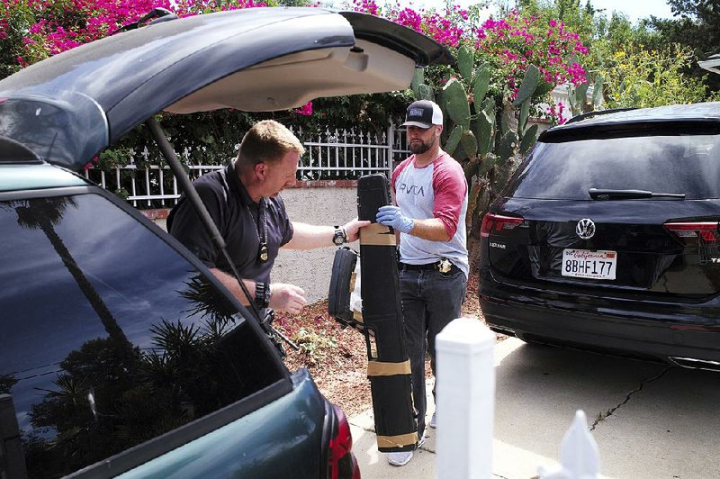 FBI agents collect evidence Thursday at the home of Robert Chain in the Encino section of Los Angeles after Chain was arrested, accused of threatening workers at The Boston Globe. 