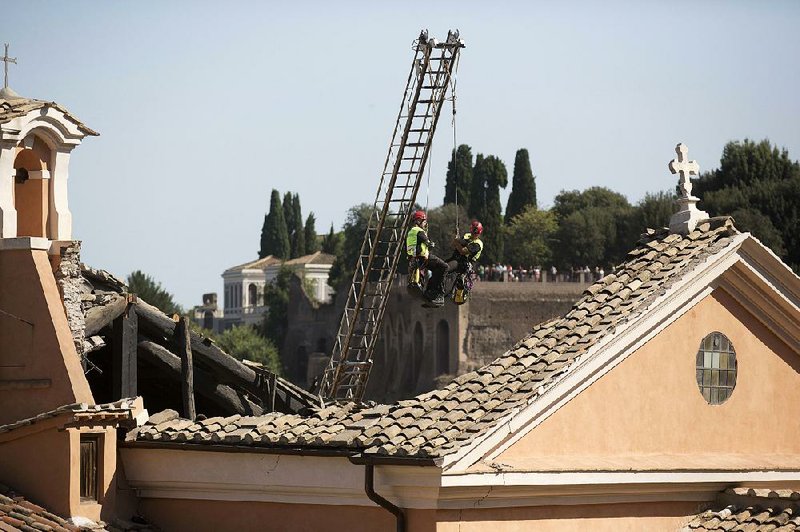 Firefighters inspect the collapsed roof Thursday on the 16th century San Giuseppe dei Falegnami in Rome. The church was closed when the roof gave way. No injuries were reported. 