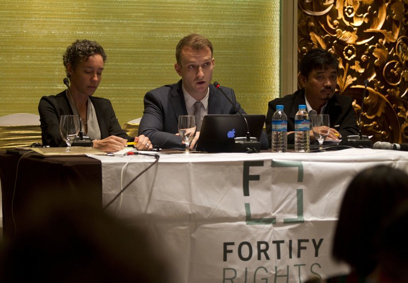 David Baulk, center, a specialist from Fortify Rights, a non-profit human rights organization, talks to journalists during a launching of a report on Myanmar's Kachin State at a hotel Thursday, Aug. 30, 2018, in Yangon, Myanmar. Others present; Amy Smith, left, executive director of Fortify Rights, and La Rip, right, executive director of Kachin Development Group (KDG). Katchin State is enmeshed in an armed conflict between the government and the ethnic rebels of the Kachin Independence Army, which has driven many civilians into refugee camps. (AP Photo/Thein Zaw)