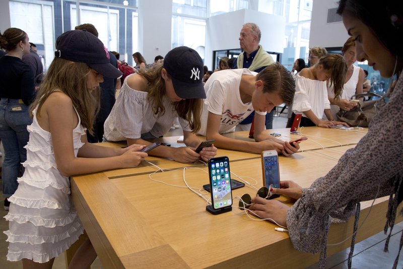 FILE- In this Aug. 2, 2018, file photo customers browse in an Apple store in New York. On Thursday, Aug. 30, the Commerce Department issues its July report on consumer spending, which accounts for roughly 70 percent of U.S. economic activity. (AP Photo/Mark Lennihan, File)