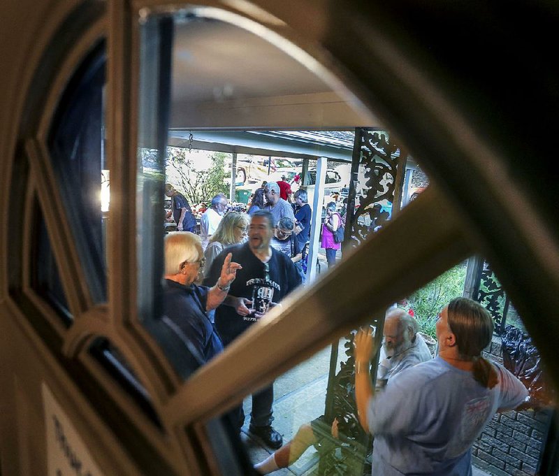 As seen through the front door, potential customers wait outside a home in Little Rock, biding their time before the door opens for a Rehome Resale  estate sale on Aug. 24.