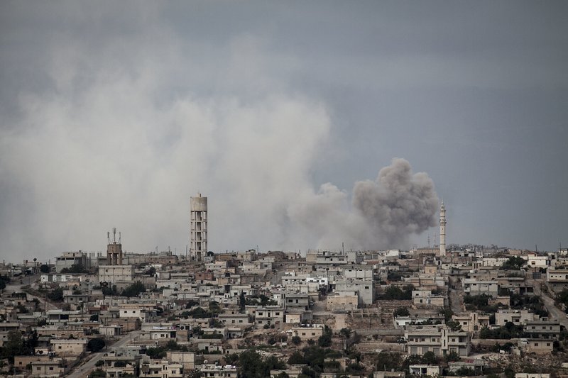 FILE - In this Sept. 19, 2013, file photo, smoke rises after a TNT bomb was thrown from a helicopter, hitting a rebel position during heavy fighting between troops loyal to president Bashar Assad and opposition fighters, in a neighbouring village to Kafr Nabuda, in the Idlib province countryside, Syria. The campaign for Idlib, the opposition&#x2019;s only remaining stronghold in the country and now a refuge for over one million displaced Syrians, is likely to be the last major theater of battle after seven years of brutal civil war. (AP Photo/File)