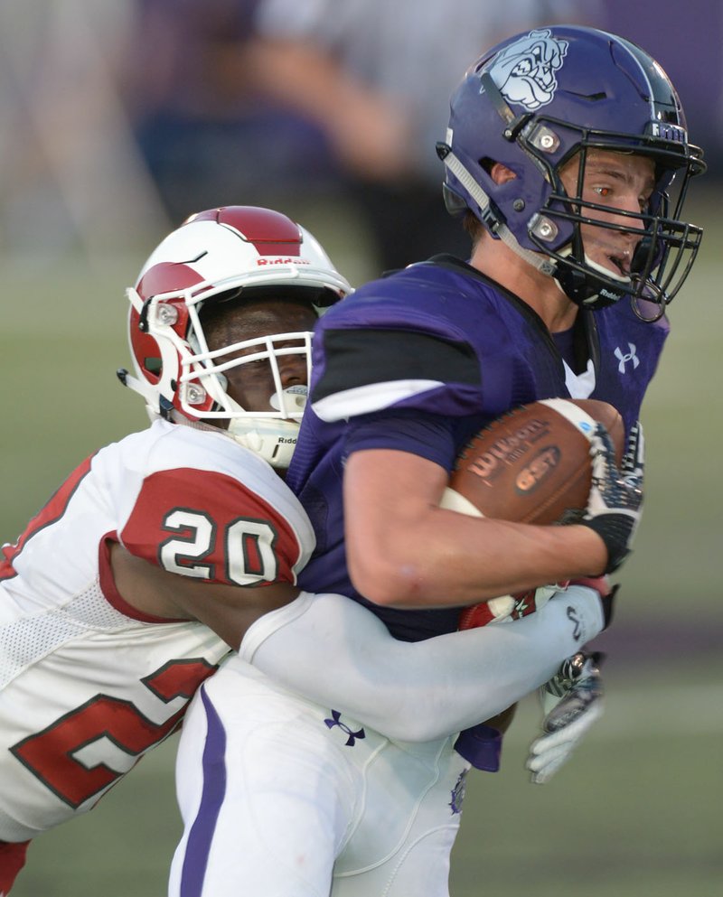 NWA Democrat-Gazette/ANDY SHUPE Fayetteville receiver Connor Flannigan (right) carries the ball as he is tackled by Owasso (Okla.) defender Omarr Barker Friday, Aug. 31, 2018, during the first half at Harmon Stadium in Fayetteville. Visit nwadg.com/photos to see more photographs from the game.