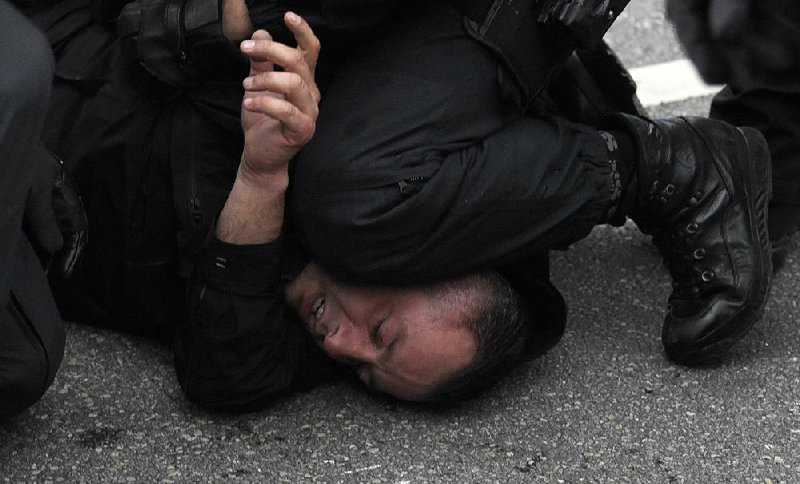 Police detain a man Saturday as they separate anti-migration demonstrators from counterprotesters in the eastern German city of Chemnitz.