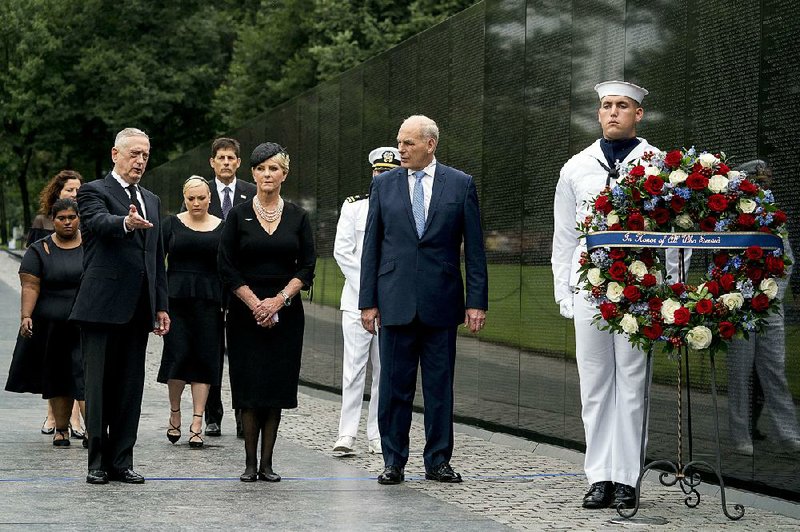 Cindy McCain, John McCain’s widow, prepares to help place a wreath at the Vietnam Veterans Memorial on Saturday in Washington. Defense Secretary James Mattis (left), White House Chief of Staff John Kelly (second from right) and McCain family members join in the ceremony. 