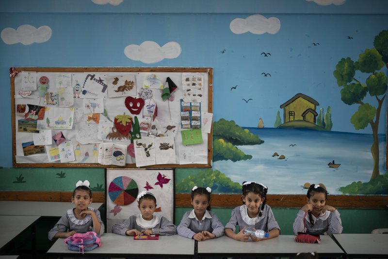File - In this Wednesday, Aug. 29, 2018 file photo, girls sit inside a classroom at an UNRWA school during the first day of a new school year in Gaza City. A spokesman for the Palestinian president says the American decision to cut funding for the U.N. agency aiding Palestinian refugees is &quot;an attack on the rights of the Palestinian people.&quot; The U.S. supplies nearly 30 percent of the total budget of the U.N. Relief and Works Agency, or UNRWA, and had been demanding it carry out significant reforms. The decision cuts nearly $300 million of planned support. (AP Photo/Felipe Dana, File)