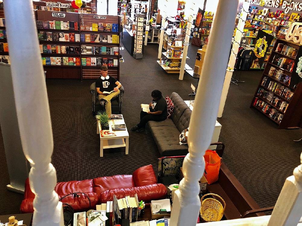 Seen from a balcony study area Aug. 28, David Peterson (left) and Denise Head enjoy the lounge area at Dog Ear Books. 