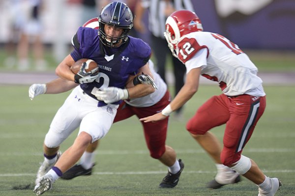 Fayetteville receiver Connor Flannigan (2) carries the ball after making a catch as he is hit by Owasso (Okla.) defender Jaden Thomason as Gage Laney (12) closes in on the play Friday, Aug. 31, 2018, during the first half at Harmon Stadium in Fayetteville.