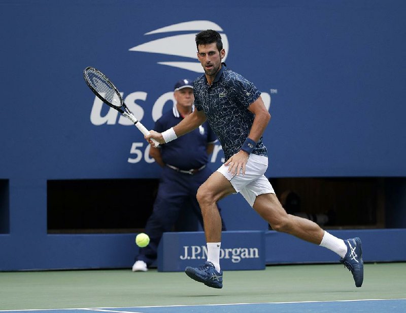 Novak Djokovic returns a shot to Joao Sousa during the fourth round of the U.S. Open on Monday in New York. Djokovic won 6-3, 6-4, 6-3 to reach the quarterfinals for an 11th consecutive appear- ance in New York as he bids for a third U.S. Open championship and 14th Grand Slam trophy.