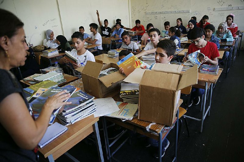 Palestinian refugee students receive new books Monday as they begin the school year at a Beirut school supported by the United Nations Relief and Works Agency.