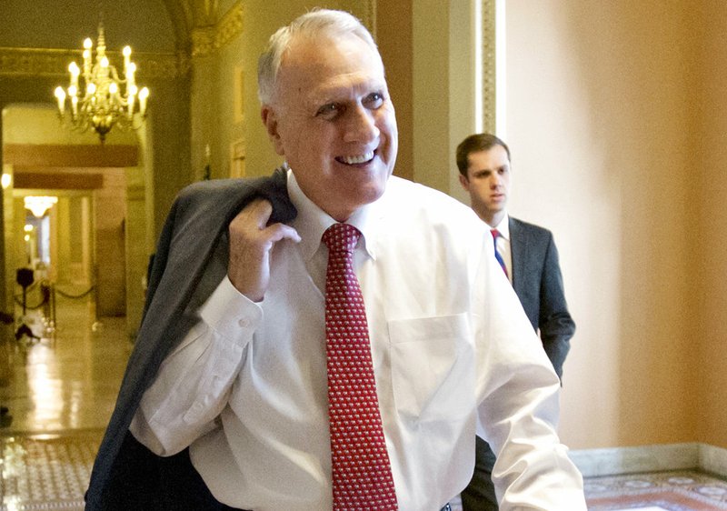 FILE - In this Dec. 30, 2012, file photo, Senate Minority Whip Jon Kyl, R-Ariz., walks between the Senate chamber and the office of Senate Minority Leader Mitch McConnell, R-Ky., in Washington. Sen. John McCain's widow on Tuesday, Sept. 4, 2018, said Kyl will fill her late husband's seat. (AP Photo/J. Scott Applewhite, File)