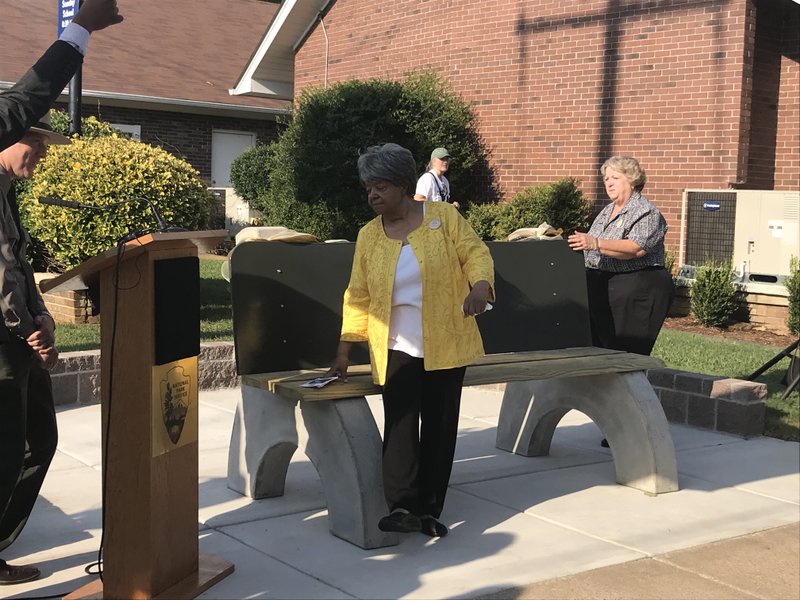 Elizabeth Eckford, a member of the Little Rock Nine, stands Tuesday, Sept. 4, 2018, near a replica of the bus-stop bench where she sought shelter from a mob protesting Central High School’s integration in 1957