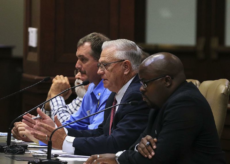 Arkansas Department of Correction officials Maj. Randy Shores (from left), Chief Deputy Director Dale Reed and spokesman Solomon Graves take questions from lawmakers Tuesday. 