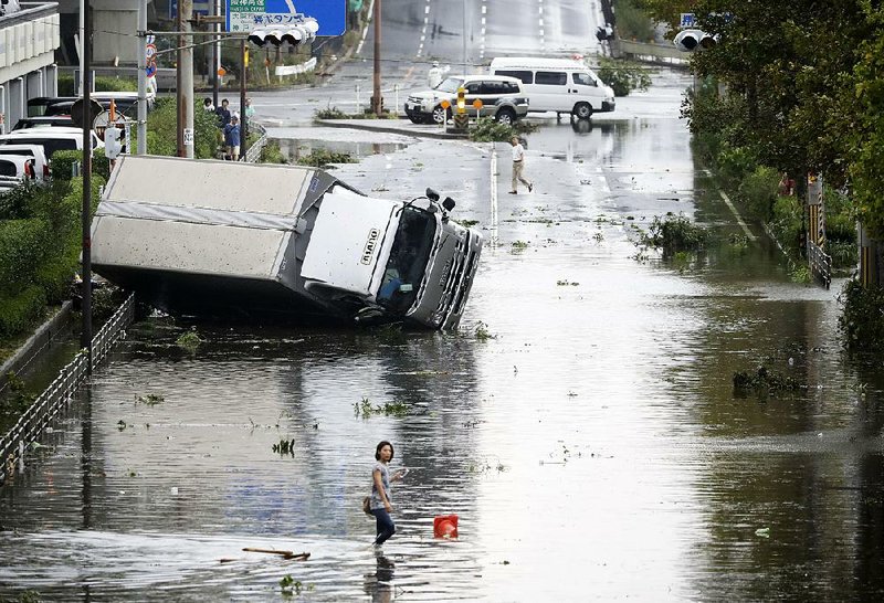 Vehicles and debris litter streets in Osaka, western Japan, after Tuesday’s typhoon. The storm disrupted travel and knocked out electricity in six prefectures. 