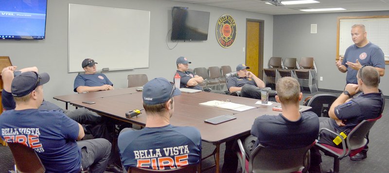 Keith Bryant/The Weekly Vista Division chief over training Scott Cranford (right, standing) briefs firefighters on a drill in the Fire Station 1 training room.