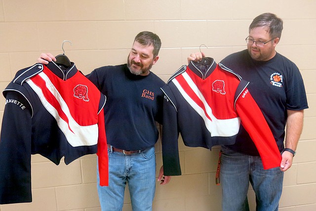 Westside Eagle Observer/SUSAN HOLLAND Aaron Ray, band director at Gravette High School, and Mark Hendrick, middle school band director, examine jackets from the high school marching band uniforms. Uniforms that needed cleaning were picked up Friday, Aug. 31, for cleaning by John Guffey of Snappy Dry Cleaning in Siloam Springs. Ray said it was a welcome donation since the uniforms had not been cleaned in several years.