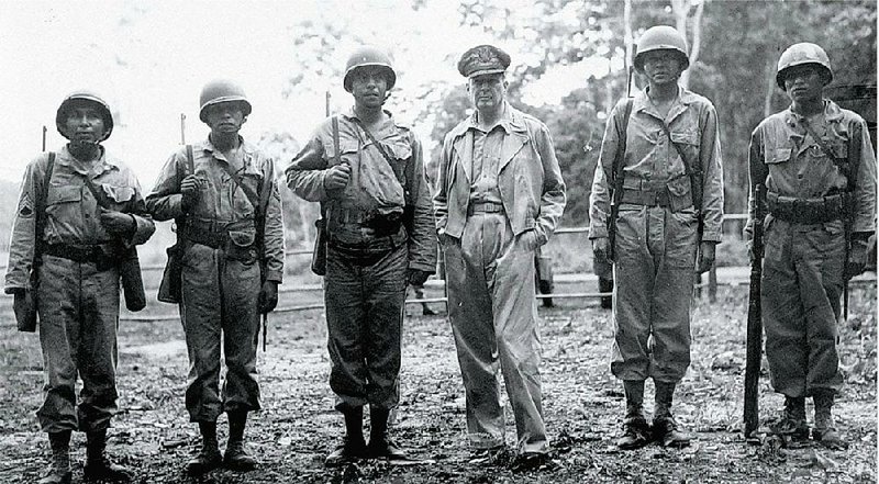 American Indian servicemen join Gen. Douglas MacArthur, commander-in-chief of the Allied forces in the South Pacific, on an inspection trip of American battle fronts in late 1943 — (from left) Staff Sgt. Virgil Brown (Pima), 1st Sgt. Virgil F. Howell (Pawnee), Staff Sgt. Alvin J. Vilcan (Chitimacha), MacArthur, Sgt. Byron L. Tsingine (Dine/Navajo), and Sgt. Larry Dekin (Dine/Navajo). The photo is part of the Smithsonian National Museum of the Ameri-can Indian’s exhibit “Patriot Nations: Native Americans in Our Nation’s Armed Forces,” on display through Nov. 30 at the University of Arkansas at Little Rock’s Sequoyah National Research Center. 
