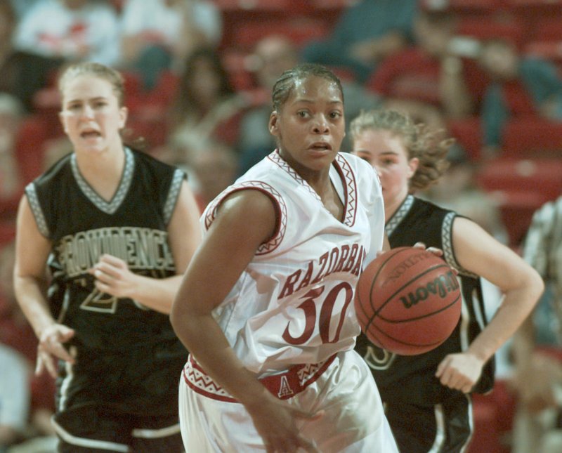 FILE PHOTO Arkansas Democrat-Gazette/MICHAEL MARSHALL Lady Razorback #30 Sytia Messer drives the ball down the court during the 1998 season opener against Providence University at Bud Walton Arena. Messer is one of 15 former Razorback athletes who will be inducted into the UA Sports Hall of Honor on Sept. 14 at the Fayetteville Town Center