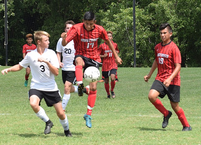 RICK PECK/SPECIAL TO MCDONALD COUNTY PRESS McDonald County's Brian Lopez goes up to settle a pass during the Mustangs' 2-1 loss to New Covenant Academy on Sept. 1 in the championship game of the Cassville High School Soccer Tournament.