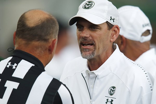Colorado State Rams head coach Mike Bobo, right, confers with head linesman Mike Moeller before facing Hawaii in the first half of an NCAA college football game Saturday, Aug. 25, 2018, in Fort Collins, Colo. Bobo, who was just released from hospital after battling a bout of peripheral neuropathy, directed his team from the press box. (AP Photo/David Zalubowski)


