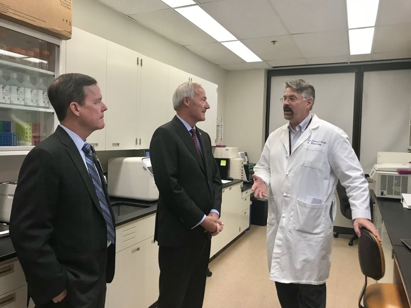 Gov. Asa Hutchinson, middle, speaks with employees at the Winthrop P. Rockefeller Cancer Institute at the University of Arkansas for Medical Sciences during a tour Wednesday, Sept. 5, 2018.