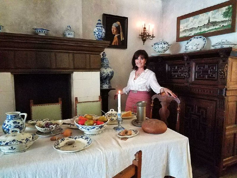 The author at the Royal Delft Museum stands in a replica of a late 17th-century Delft dining room. 