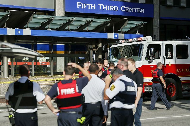 Cincinnati emergency personnel work Thursday outside the 30-story Fifth Third Bancorp building, where a gunman opened fire, killing three people before officers killed him.