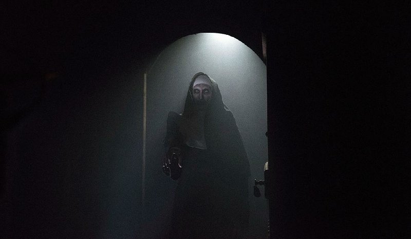 This is a spooky photo of a nun (Bonnie Aarons) in the spooky movie The Nun which is apparently about spooky nuns.
