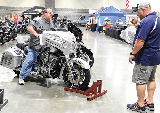 The Sentinel-Record/Grace Brown SETTING UP: Eric Teed, right, directs Lance "The Fridge" McKellips as he positions an Indian Motorcycle inside the Hot Springs Convention Center on Thursday, in preparation for The Hot Springs Rally today through Sunday.