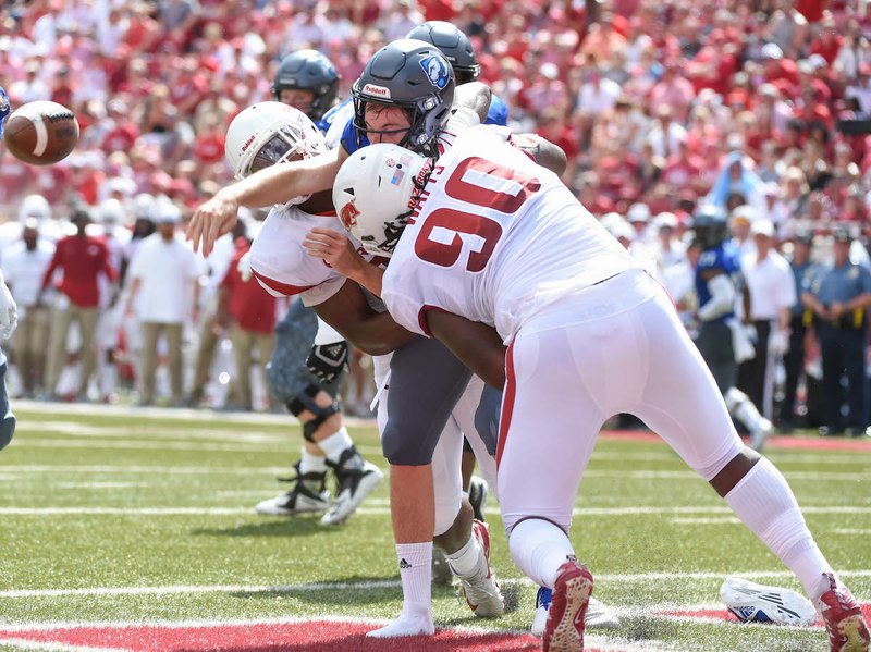 Special to The Sentinel-Record/Craven Whitlow DEFENSIVE PRESSURE: Arkansas senior defensive lineman Armon Watts (90) strips the ball from the Eastern Illinois quarterback Harry Woodberry Saturday at Donald W. Razorback Stadium in Fayetteville.