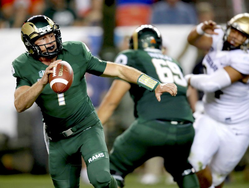 FILE--In this Friday, Aug. 31, 2018, file photograph, Colorado State quarterback K.J. Carta-Samuels rolls out to pass under pressure during the second half of an NCAA college football game against Colorado in Denver. Colorado won 45-13. Carta-Samuels and the Rams will host Arkansas on Saturday. (AP Photo/David Zalubowski, File)