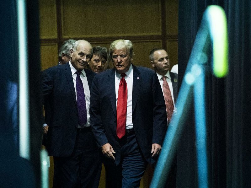 White House Chief of Staff John Kelly talks with President Donald Trump backstage Friday during a reception in Sioux Falls, S.D. 